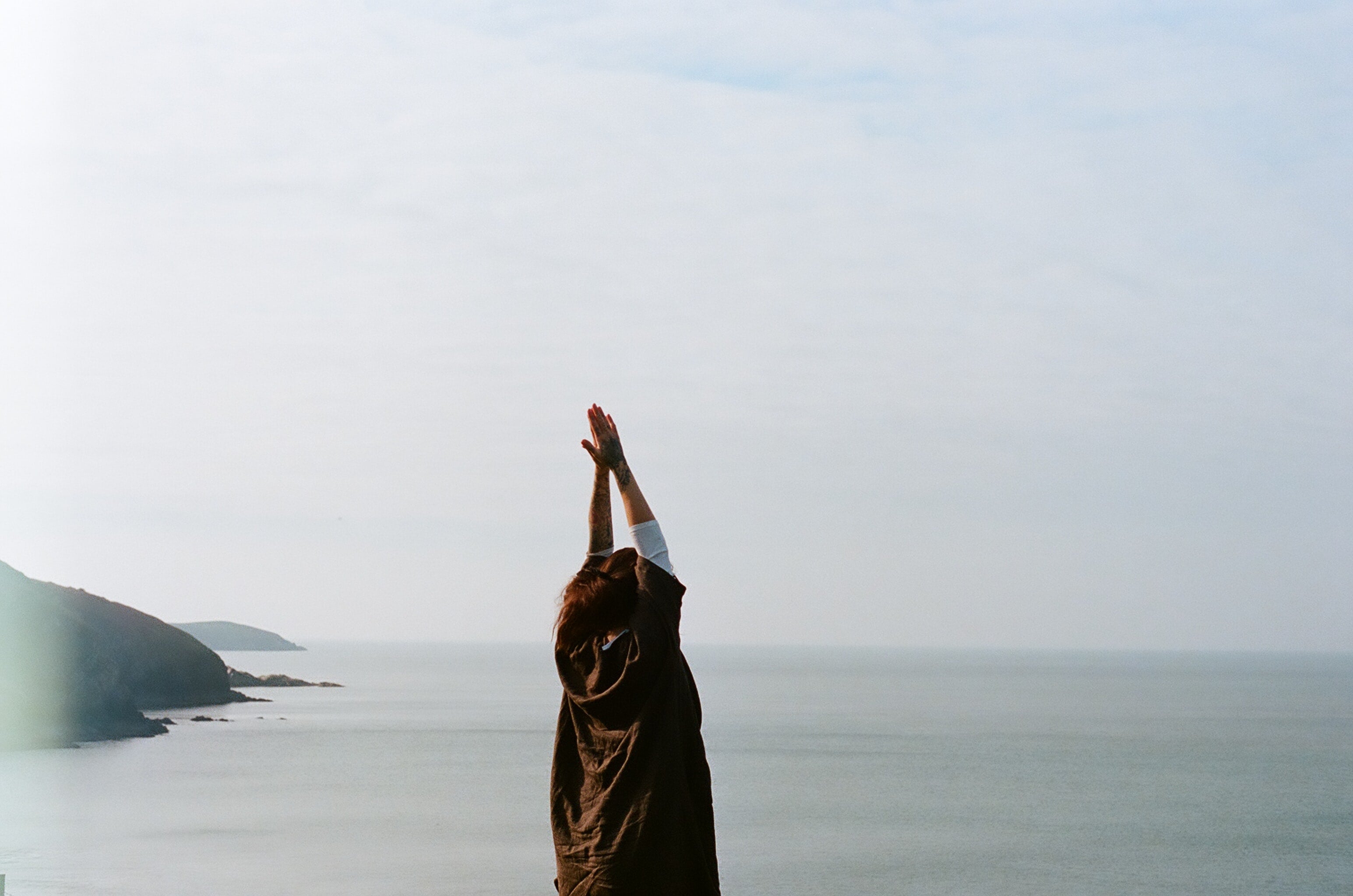 woman doing yoga in front of water