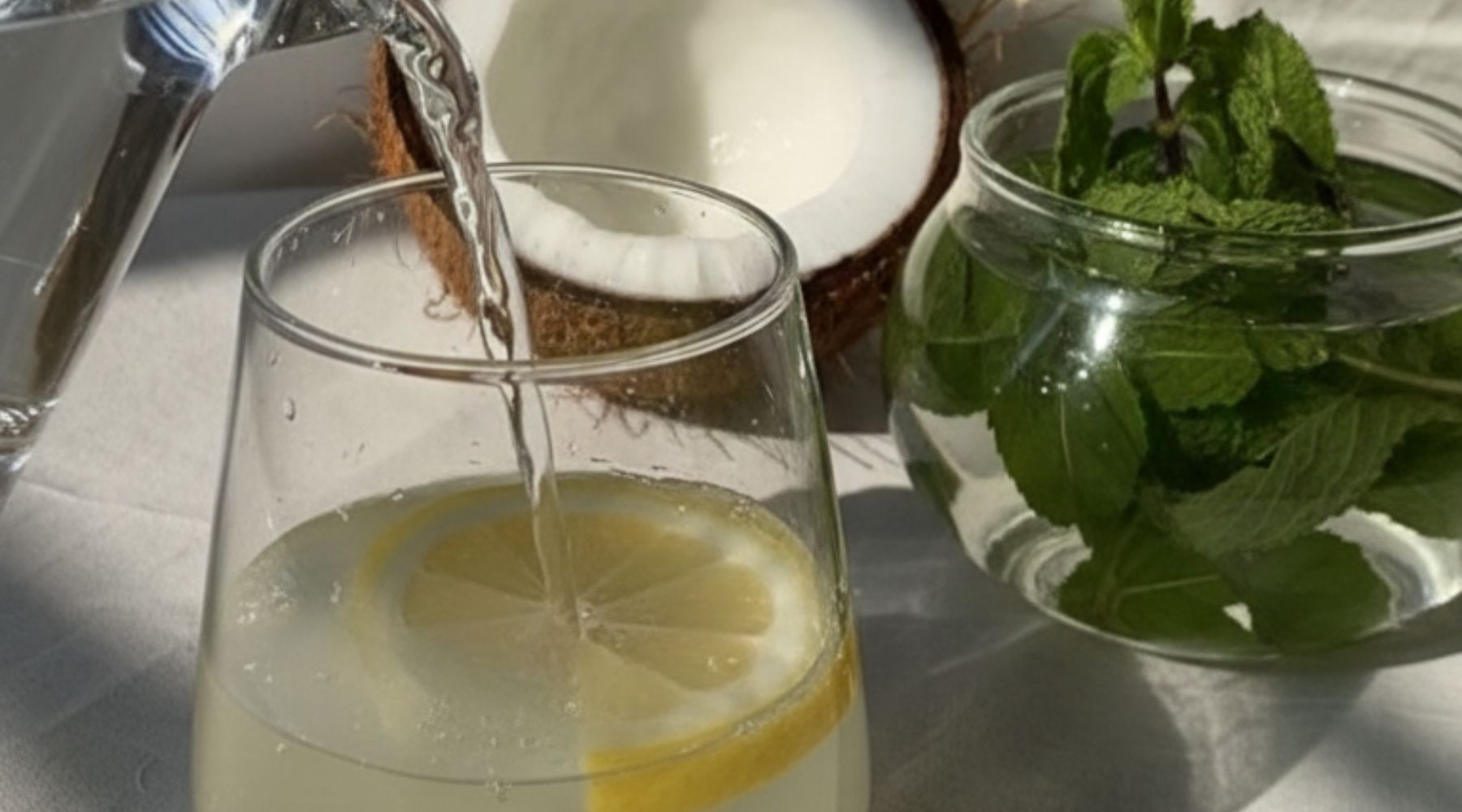 Mocktail à la camomille et à l’eau de coco, servi sur glace avec feuilles de menthe et tranche d’agrume, dans une ambiance douce et apaisante.
