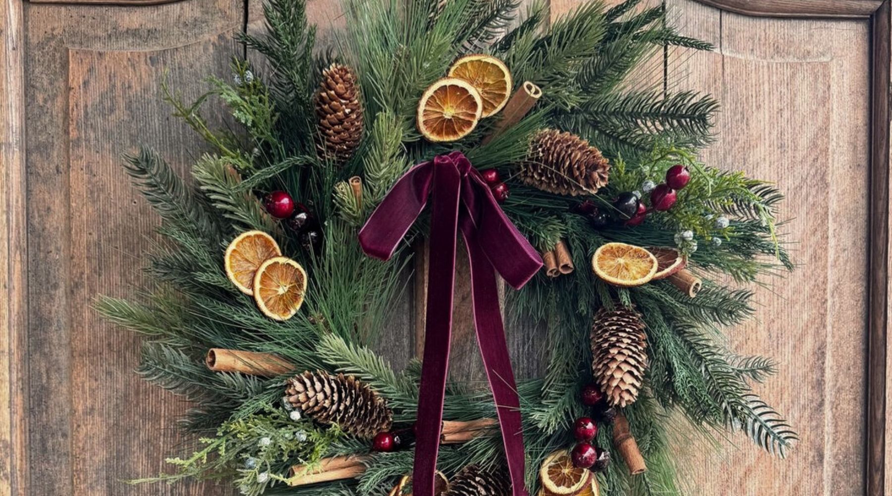 Couronne de Noël décorée de branches de pin et d’ornements festifs.