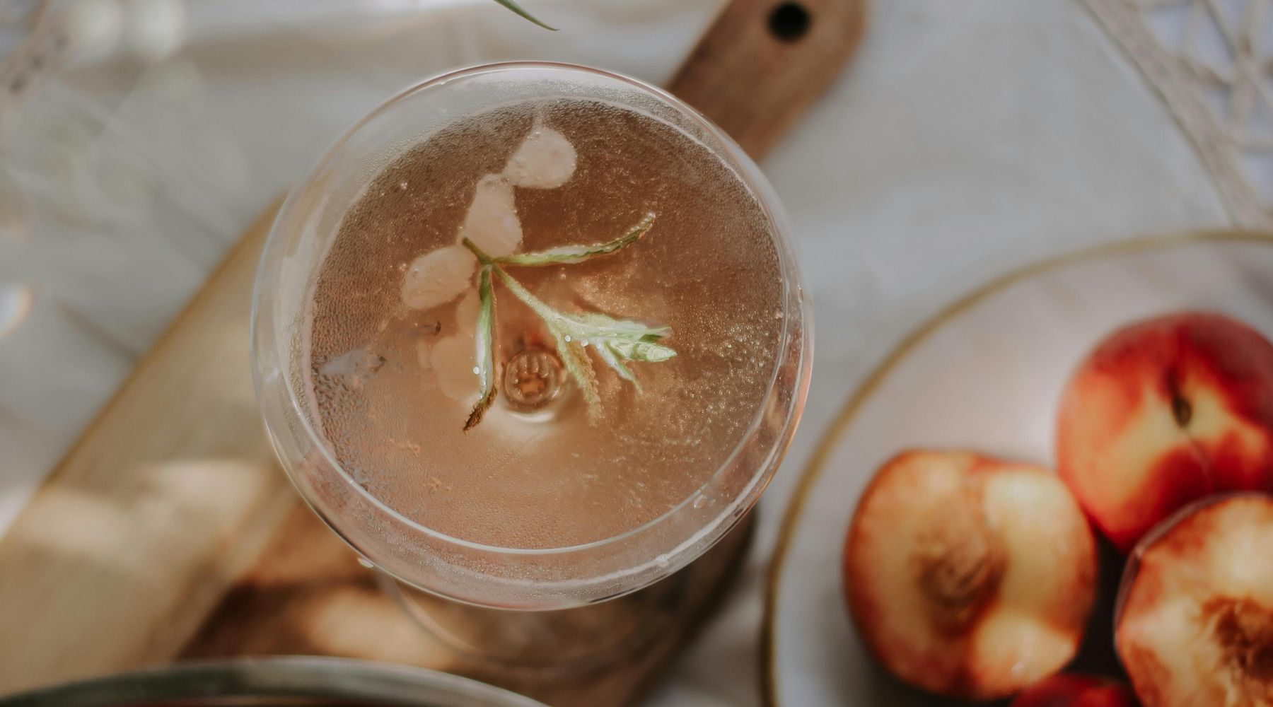 Mocktail hivernal à la pêche et au gingembre, servi dans un verre avec glaçons, tranches de pêche, rondelles de citron et garniture de menthe.