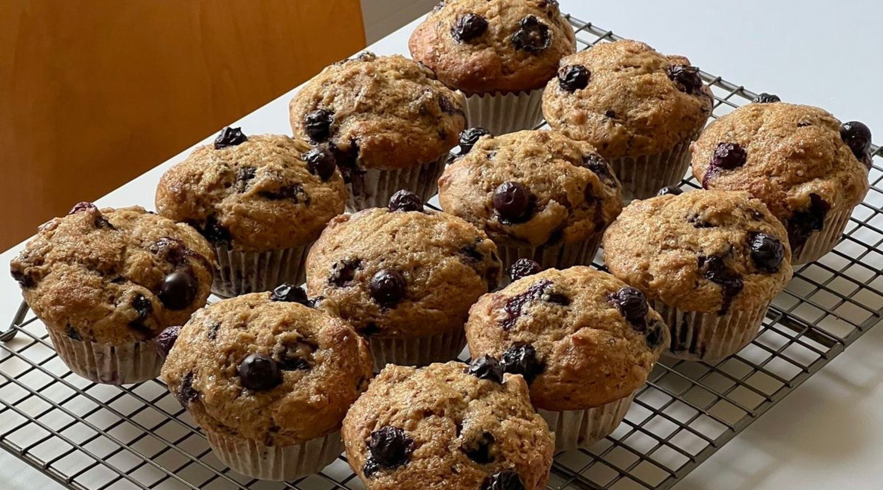 Muffins maison à la poire et au cassis, dorés et moelleux, servis sur une assiette dans une ambiance festive et chaleureuse de décembre.