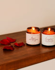 Ensemble de deux bougies parfumées : Rose et Champagne et Camphre et Cachemire, dans des contenants en verre.