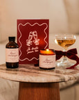 Ensemble de trois produits Rose et Champagne avec une bougie parfumée, un bain moussant et une carte.